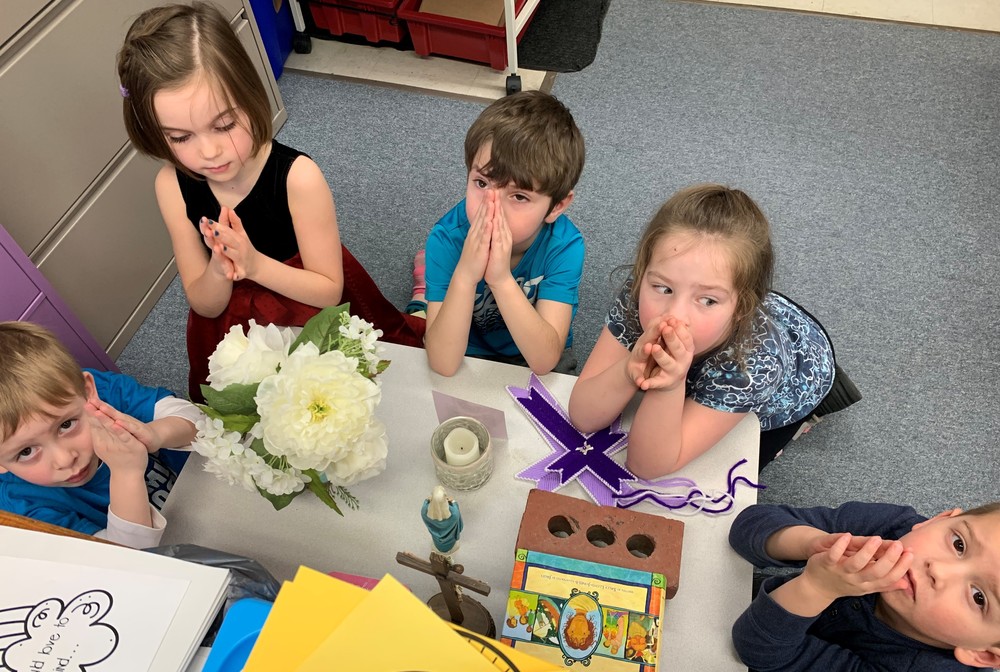 Preschool students pray for their prayer buddies