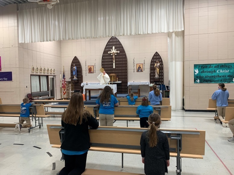 8th grade and Kindergarten buddies attend Eucharistic Adoration during Lent.